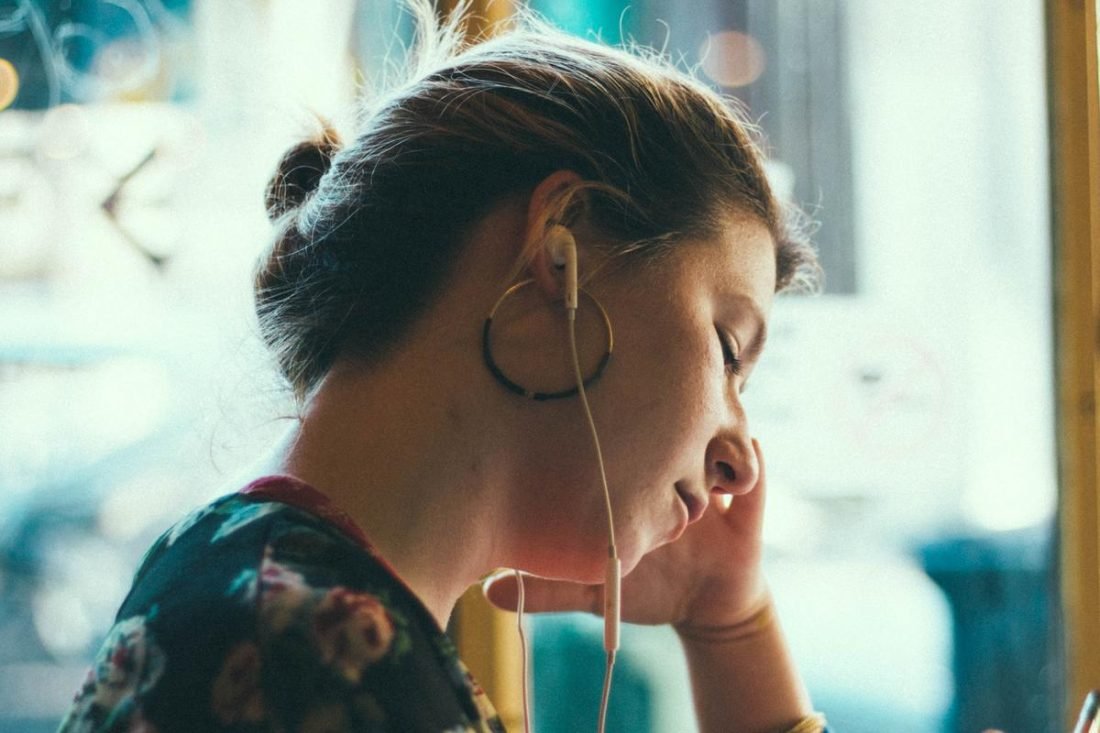 Auriculares que dañan el oído interno de una mujer (De: Unsplash)
