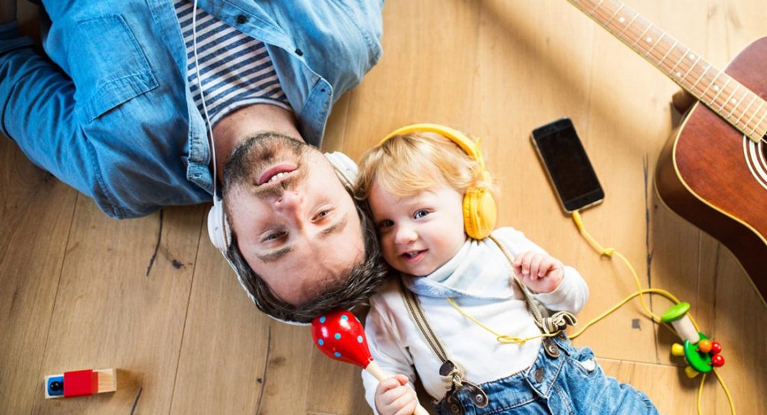 Un padre y su hijo pequeño usando auriculares (de babycentre.co.uk)