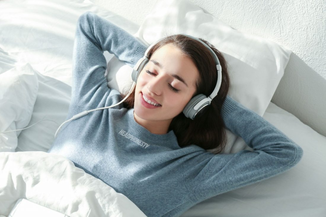 mujer durmiendo en la cama con auriculares